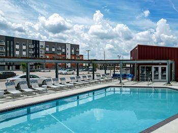 A large swimming pool with lounge chairs and a building in the background.at Linc, Iowa, 50309